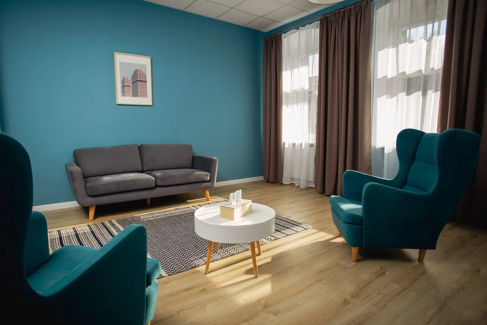 Gabinet psychologiczny z turkusowymi fotelami i kanapą w Centrum Consilia